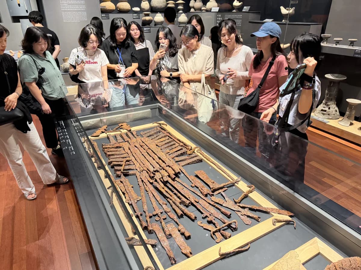 해설사와 함께 박물관 전시 모형을 살펴보는 여행자들
